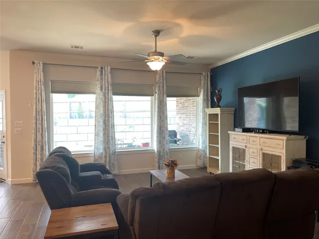 a living room with furniture a flat screen tv and a chandelier