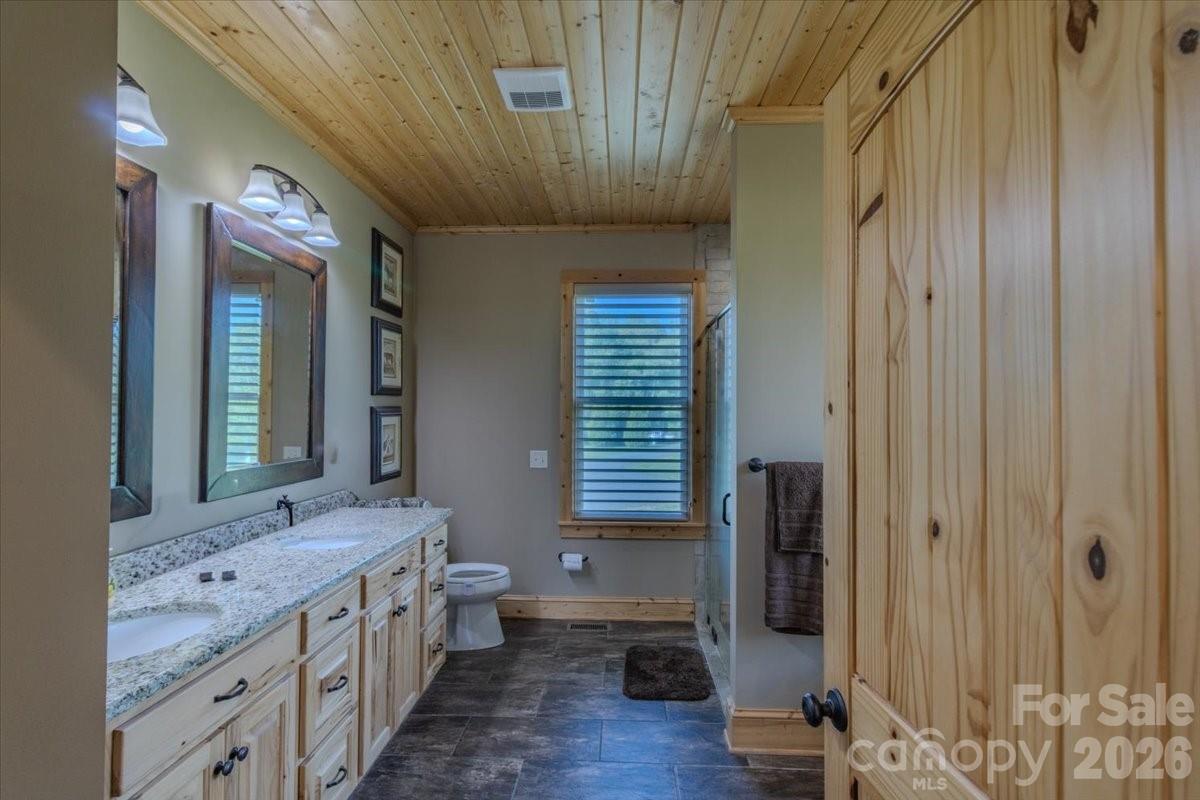 1083 Union Community Road Thurmond, NC 28683 - Photo 17 of 47 a bathroom with a double vanity sink toilet mirror and bathtub