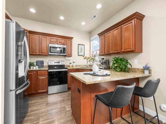 834 West 1050th Street South Springville, UT 84663 - Photo 4 of 26 Kitchen featuring wood-finish flooring and rich wood cabinetry with crown molding