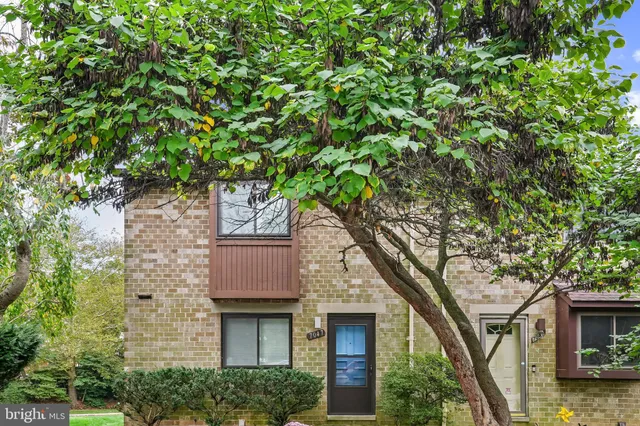 a front view of a house with a tree