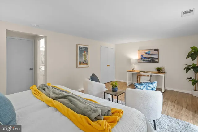 a bedroom with a bed wooden floor and lamp