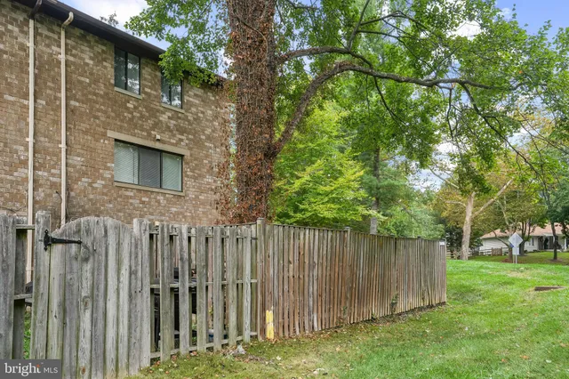 a view of a brick house with wooden fence