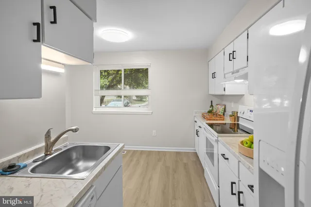 a kitchen with a sink a stove and cabinets