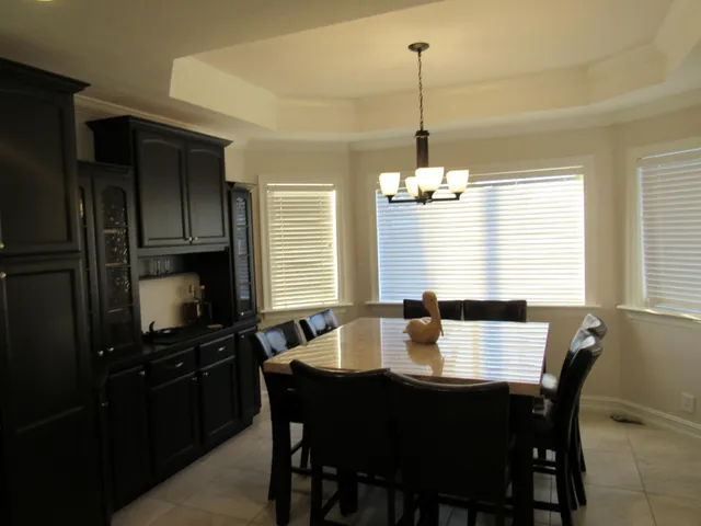 a dining room with a table chairs and kitchen view