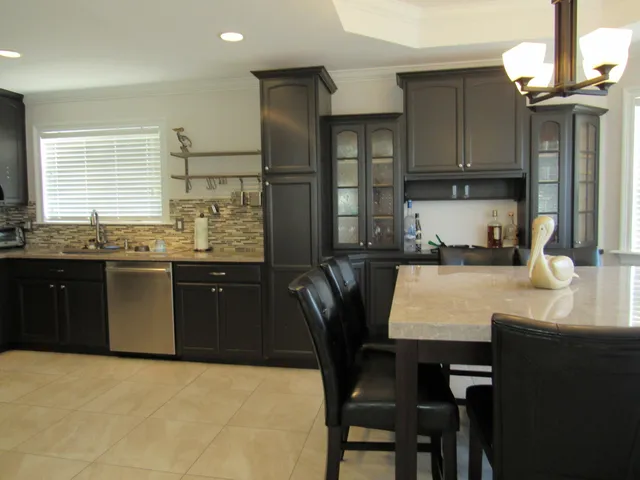 a kitchen with granite countertop a sink appliances cabinets and dining table