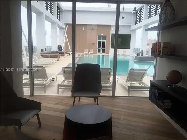 a living room with couches chairs and a coffee table with wooden floor