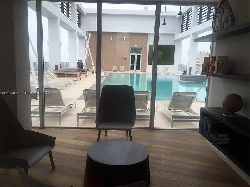 151 Southeast 1st Street, Unit 3010 Miami, FL 33131 - Photo 20 of 22 a living room with couches chairs and a coffee table with wooden floor