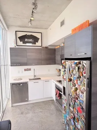 a view of a kitchen with stainless steel appliances cabinets and a window