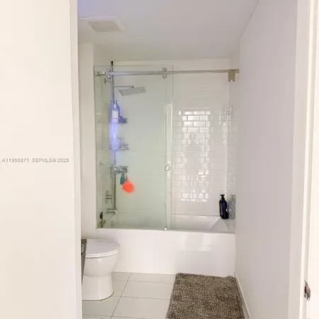 a bathroom with a bathtub shower sink vanity and toilet