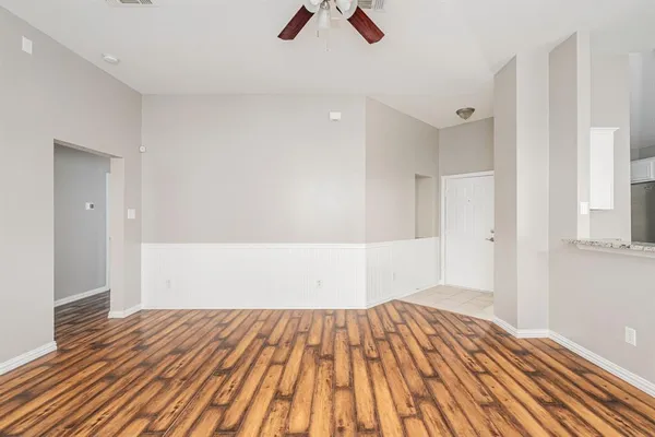a view of empty room with wooden floor