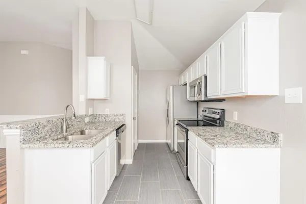 a kitchen with stainless steel appliances granite countertop a sink stove and cabinets