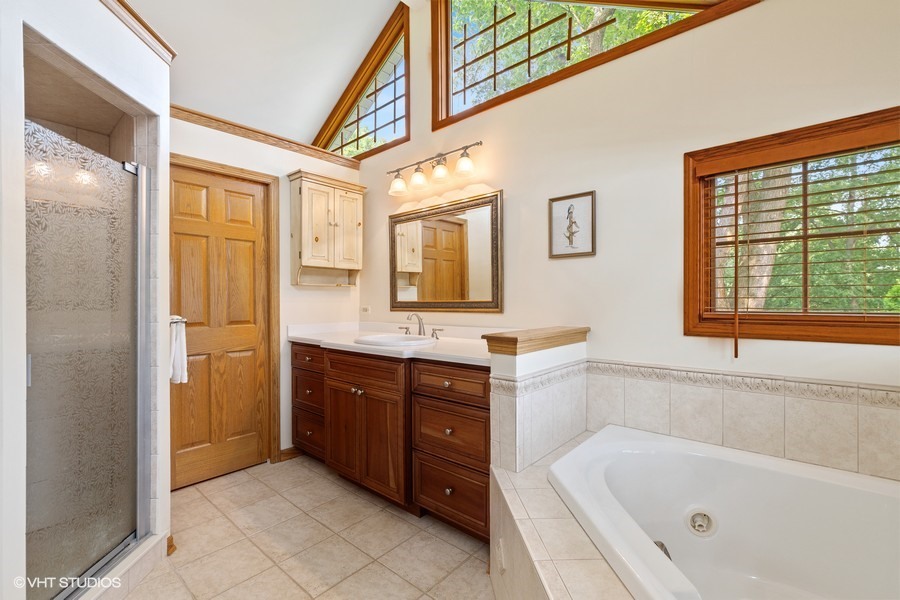 323 Wagner Road Northfield, IL 60093 - Photo 15 of 18 a bathroom with a tub sink and mirror