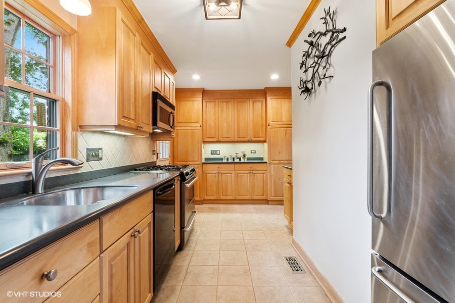 323 Wagner Road Northfield, IL 60093 - Photo 8 of 18 a kitchen with stainless steel appliances granite countertop a refrigerator a sink and a stove