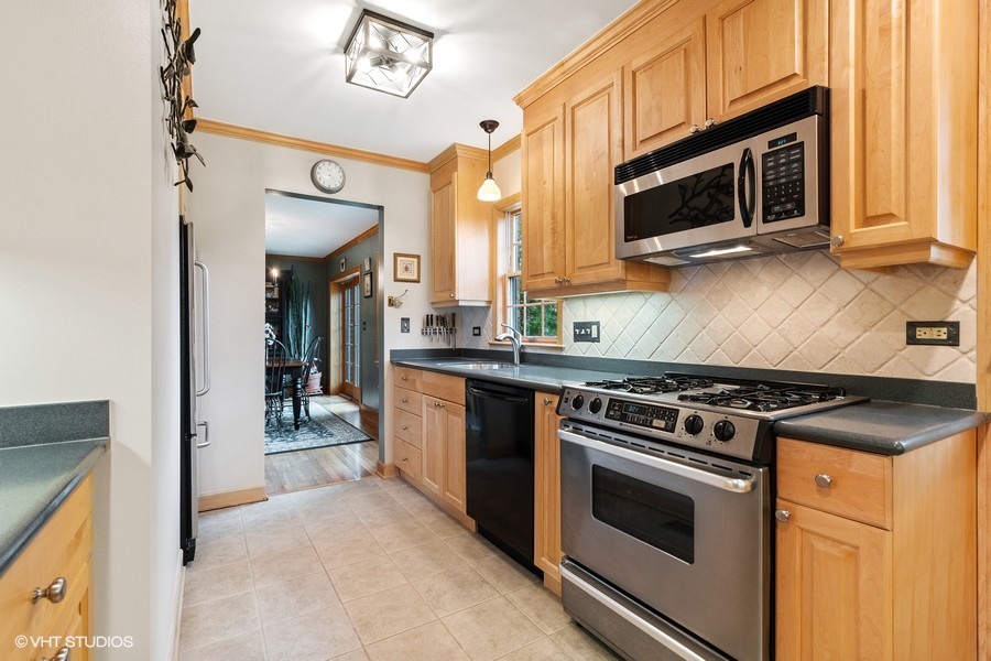 323 Wagner Road Northfield, IL 60093 - Photo 9 of 18 a kitchen with stainless steel appliances a stove a microwave and cabinets