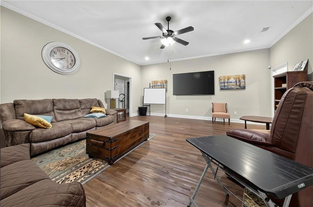 5 Fast Lane Seale, AL 36875 - Photo 5 of 13 Spacious recreation room featuring hardwood flooring, a ceiling fan with integrated lighting, and a wall-mounted flat-screen television