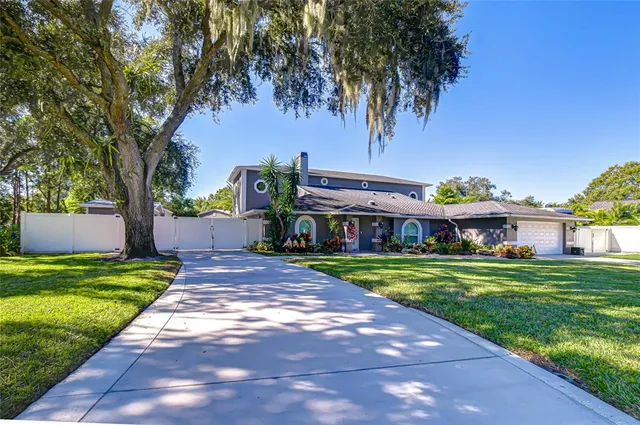 a front view of a house with a yard and trees