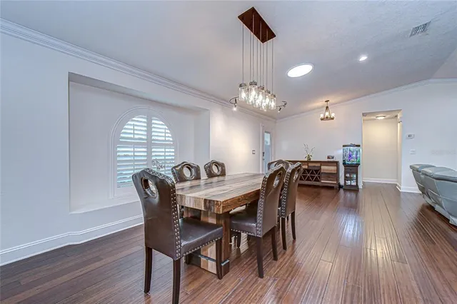a kitchen with stainless steel appliances kitchen island granite countertop a table chairs and a refrigerator