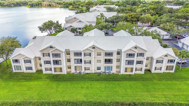 an aerial view of residential houses with outdoor space and trees