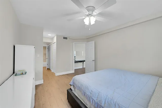 a spacious bedroom with a bed and a chandelier