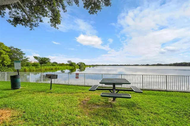 a sign of golf club on a wall under a tree