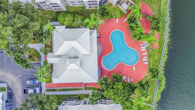 a front view of a house with a garden and palm trees