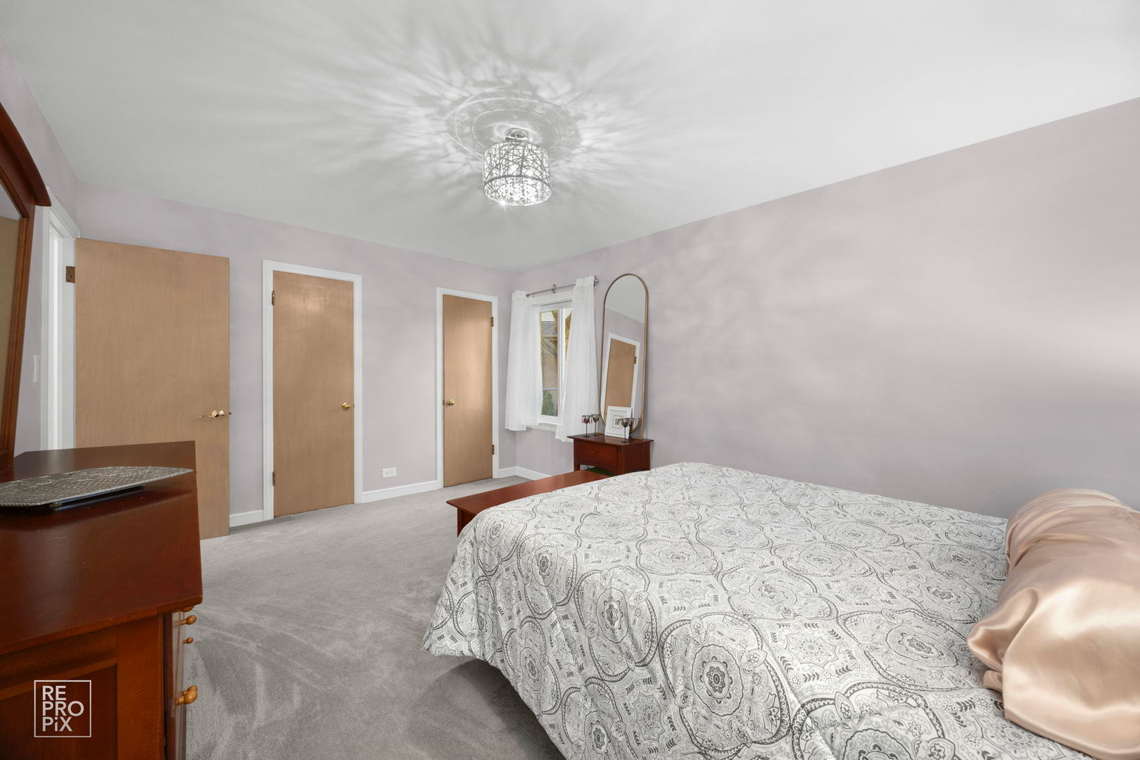 6872 North Loron Avenue Chicago, IL 60646 - Photo 20 of 25 a bedroom with a large bed and a chandelier
