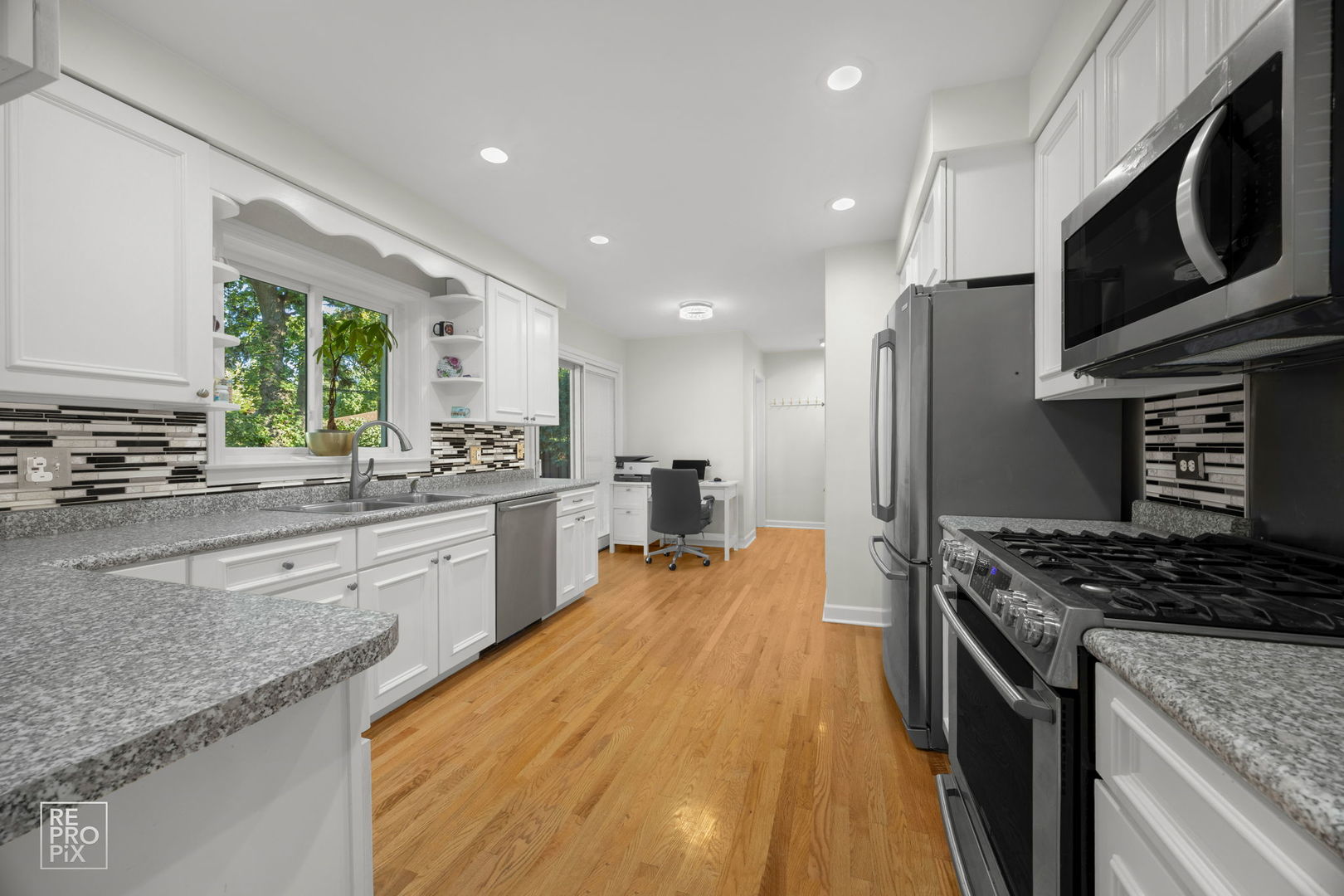 6872 North Loron Avenue Chicago, IL 60646 - Photo 5 of 25 a kitchen with stainless steel appliances granite countertop a stove a sink dishwasher a refrigerator and a microwave