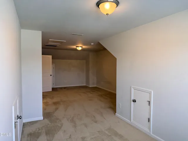 an empty room with closet and a bathroom