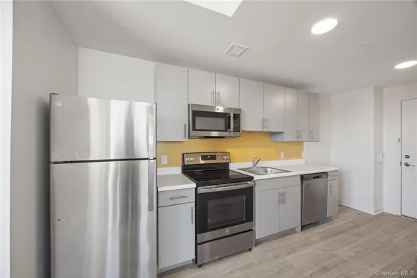 a kitchen with a refrigerator sink and stove top oven