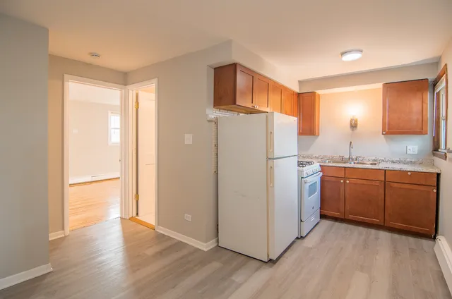 a kitchen with sink refrigerator and cabinets
