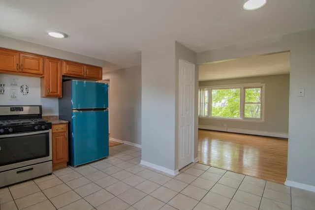 a kitchen with granite countertop a refrigerator and a stove top oven