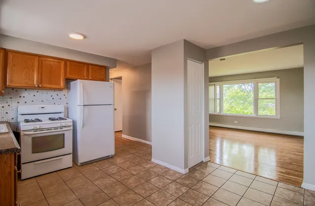 a kitchen with a refrigerator a stove top oven and cabinets