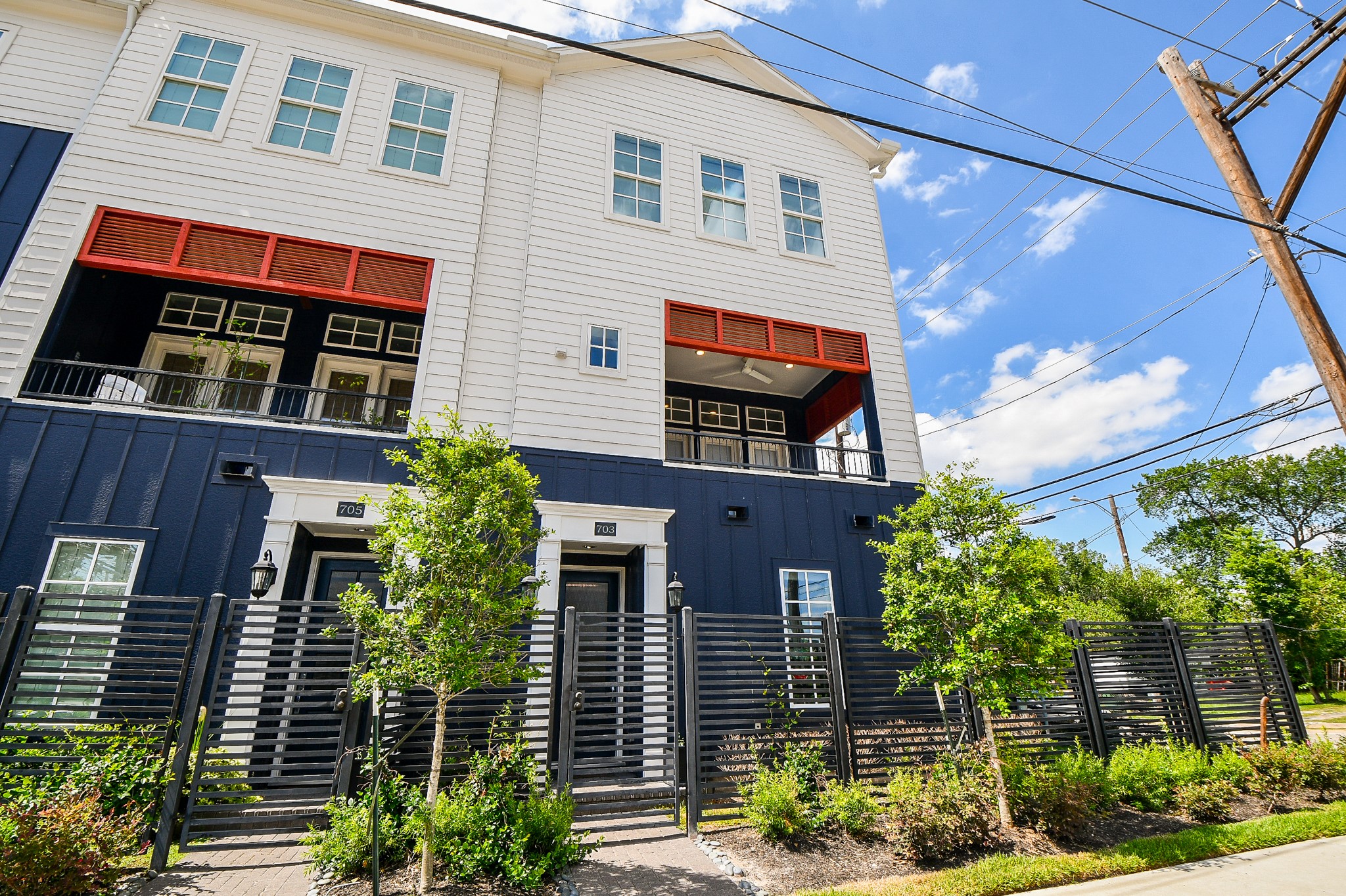 This modern open-concept living
space features sleek hardwood
floors, a large kitchen island with a
luxurious countertop, and stylish
pendant lighting. The room is bright
with natural light from multiple
windows and has a ceiling fan for
comfort. A staircase with a
contemporary railing leads to the
upper level, and double doors open
to a balcony, enhancing indoor-outdoor living.