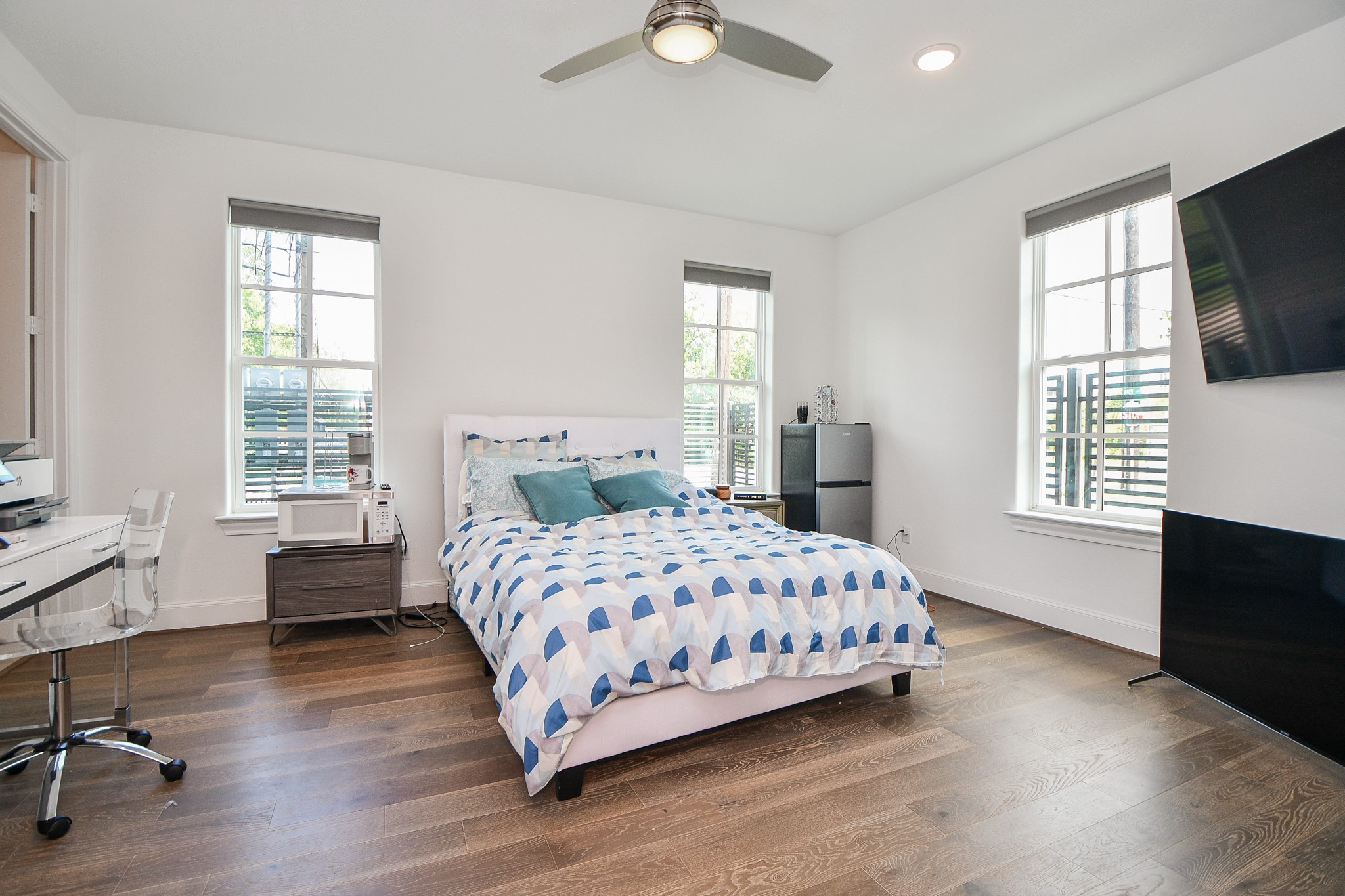703 Bringhurst Street Houston, TX 77020 - Photo 21 of 27 This bedroom features a modern design with a spacious layout. It includes a large bed, hardwood floors, ceiling fan, and a walk-in closet. There's
also an en-suite bathroom, creating a
convenient and comfortable living
space.