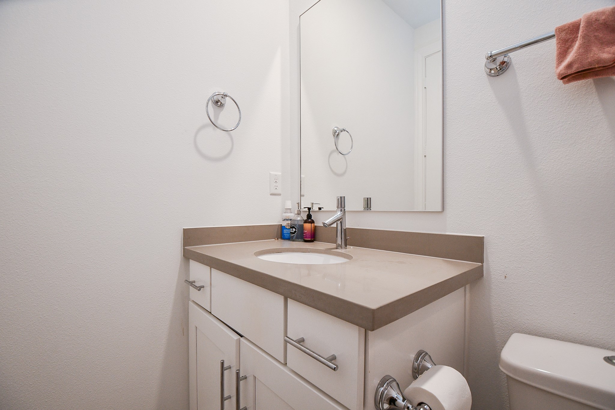 703 Bringhurst Street Houston, TX 77020 - Photo 23 of 27 Modern bathroom with a sleek, large mirror and a stylish white vanity featuring a neutral countertop