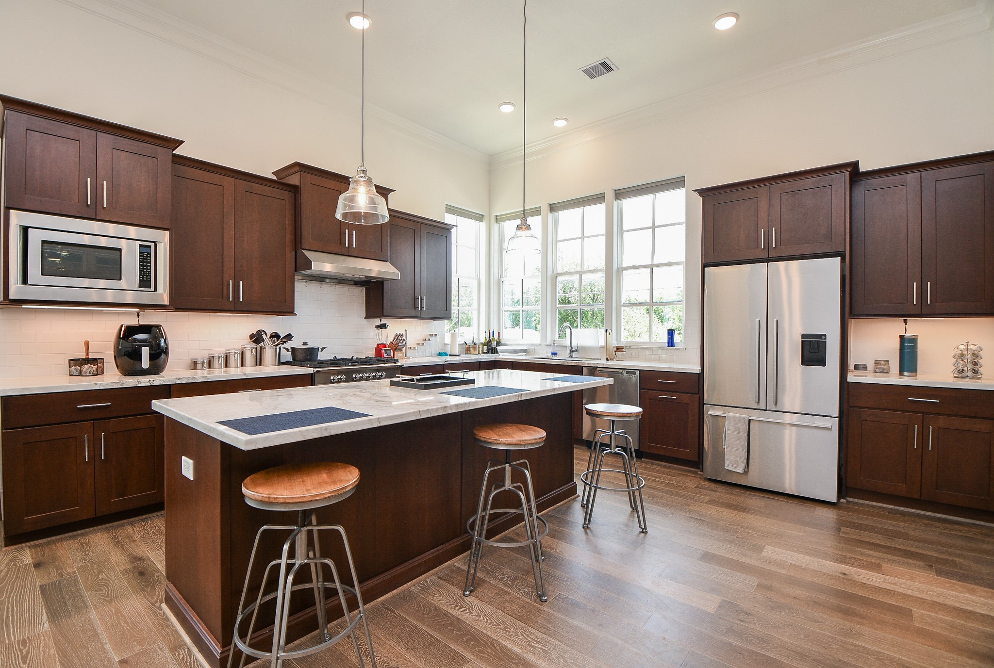 703 Bringhurst Street Houston, TX 77020 - Photo 9 of 27 This kitchen features sleek maple cabinetry, a modern stainless steel
gas stove, and elegant black subway
tile backsplash. The countertops
showcase a stylish marble-like
design, creating a
sophisticated feel.