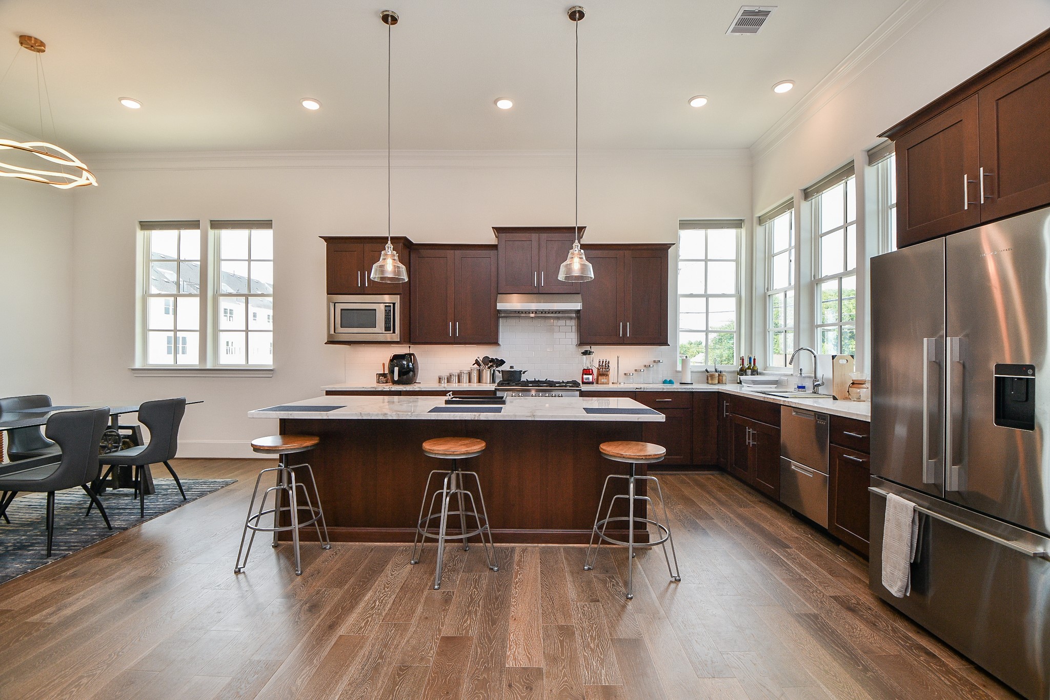 703 Bringhurst Street Houston, TX 77020 - Photo 10 of 27 This modern living space features an
open layout with a sleek black
sectional sofa, hardwood floors, and
a stylish kitchen area with stainless
steel appliances. The room is bright
with natural light and includes
contemporary lighting fixtures and a
staircase with a minimalist railing
design.