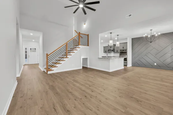 a view of a kitchen with wooden floor and a ceiling fan
