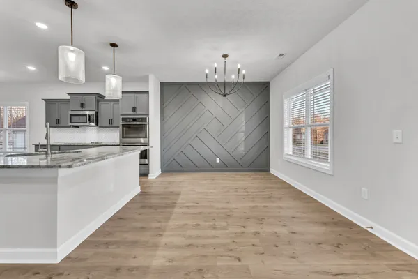 a large kitchen with kitchen island a sink stainless steel appliances and cabinets