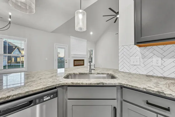 a kitchen with granite countertop stainless steel appliances sink stove and microwave