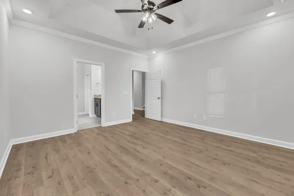 a view of empty room with wooden floor and ceiling fan