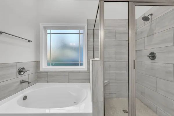 a white bath tub sitting next to a shower