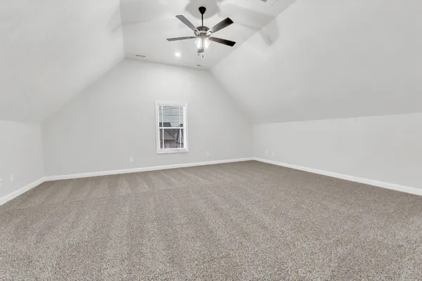 an empty room with a window and ceiling fan