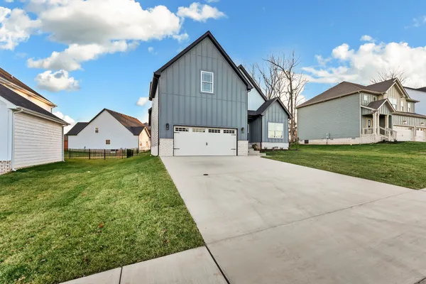 a view of a house with a yard and large tree