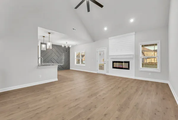 an empty room with windows and fireplace