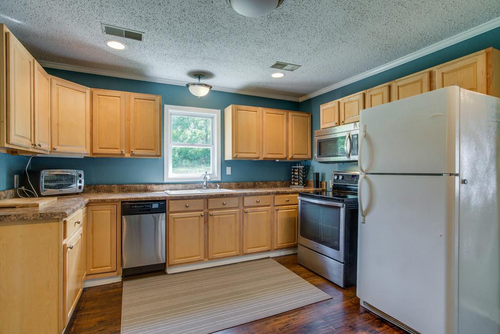 4467 Kedron Road Spring Hill, TN 37174 - Photo 4 of 14 a kitchen with granite countertop stainless steel appliances a refrigerator cabinets and wooden floor