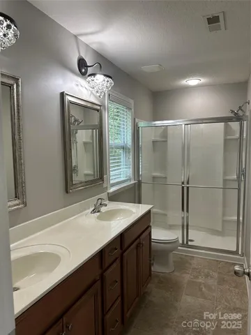 a bathroom with a sink double vanity granite and a shower