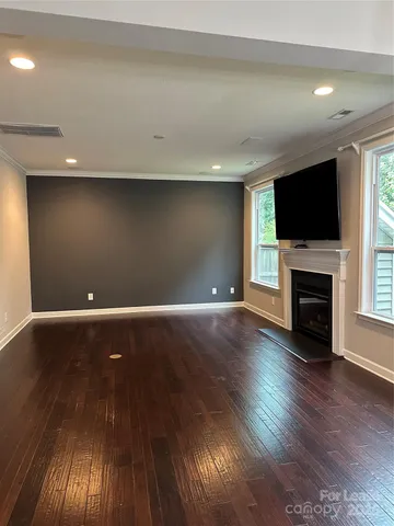 an empty room with wooden floor and a fireplace