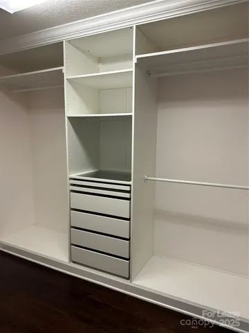 a view of walk in closet with empty racks
