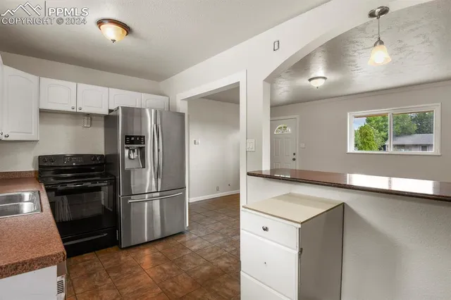 a kitchen with a refrigerator sink and cabinets